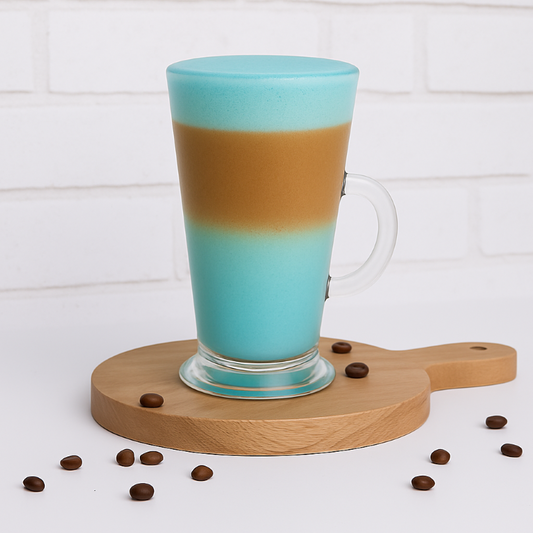 Turquoise and brown layered mug on a wooden coaster with scattered coffee beans.