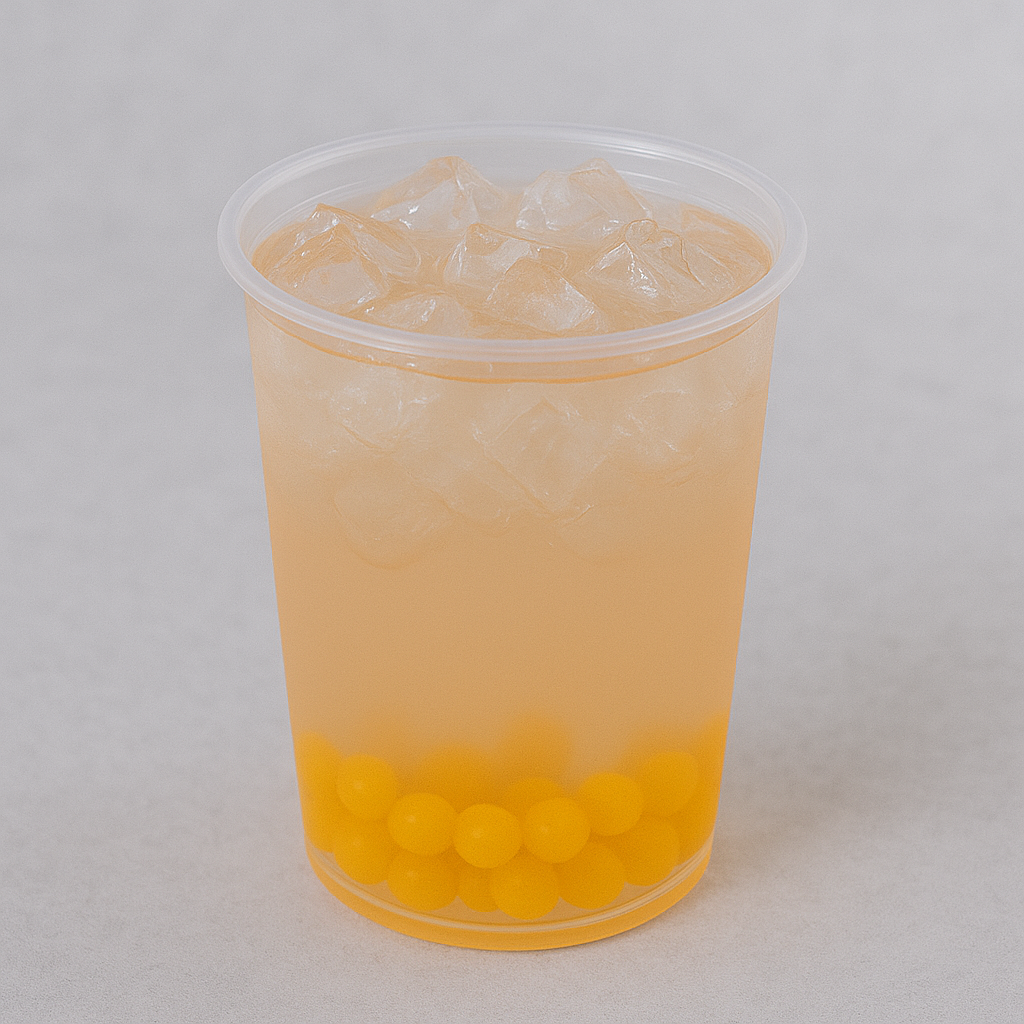 Clear plastic cup with a yellow beverage and ice cubes on a light gray background