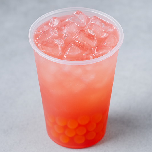 Clear plastic cup with pink iced drink and red boba on a light gray background