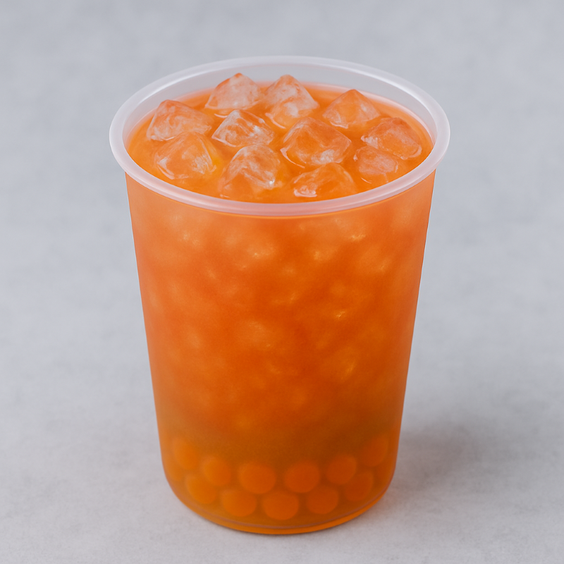 Orange beverage with ice cubes in a clear plastic cup on a gray background